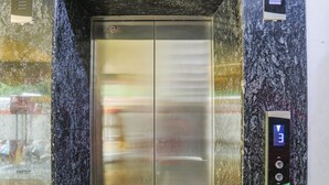 An elevator with a digital display and buttons, set in a marble-floored area. - Fabhotel Naman (Kanpur)