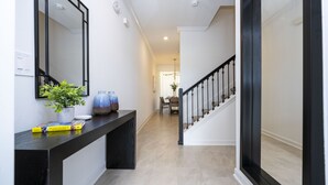 A hallway with a black console table, a potted plant, and a mirror. - BRAND-NEW 4BD/3BTH Townhome near Disney #141 (Kissimmee)