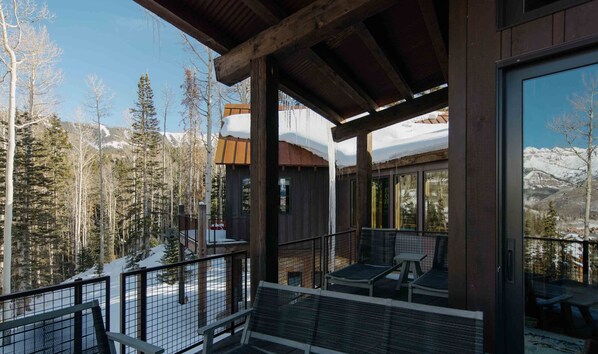 A wooden cabin with a balcony overlooking a snowy mountain landscape. - Elevated Mountain Ski Home by InvitedHome | New Remodel, Patio Views, Game Room (Mountain Village)