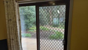 Una habitación con puerta corrediza de vidrio que da a un jardín.