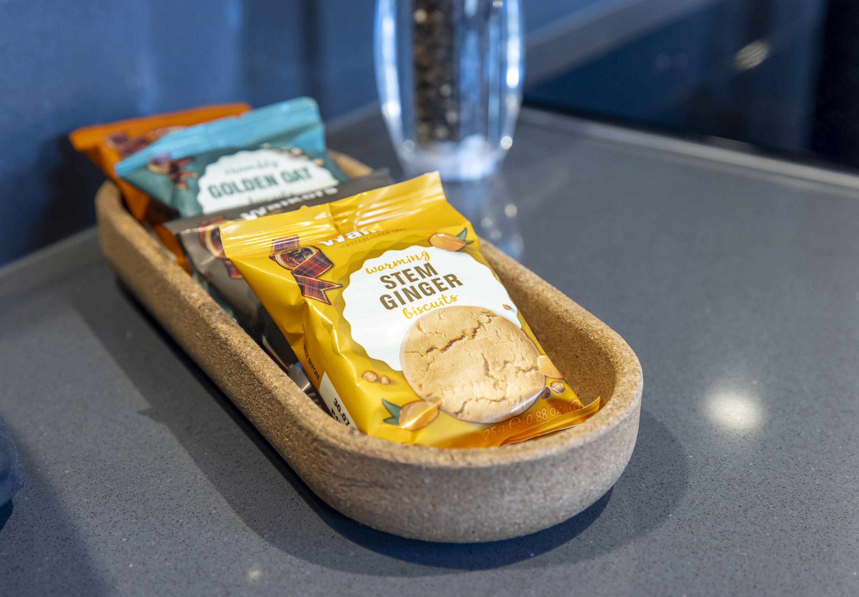 A tray with two packages of ginger biscuits and a small container.