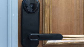 A modern door lock with a numeric keypad and a keyhole.