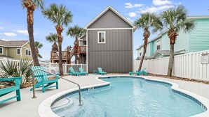 A swimming pool with a 3 FT depth marker, surrounded by turquoise lounge chairs and palm trees. - Trinity Tides, the waves dance, and so do your worries (Port Aransas)