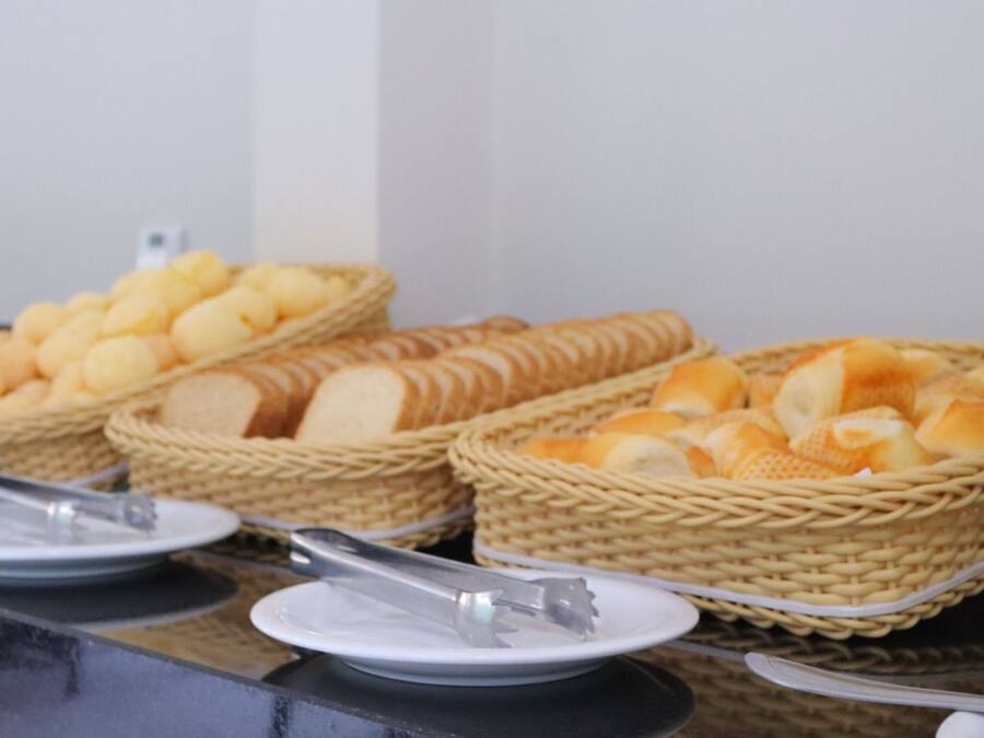 A buffet table with baskets of bread and rolls.