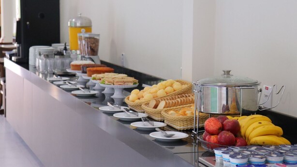 A buffet with various food items including sandwiches, fruits, and beverages. - Fly Hotel (Varzea Grande)