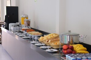 A buffet with various food items including sandwiches, fruits, and beverages. - Fly Hotel (Varzea Grande)
