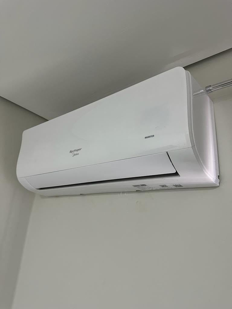 Un aire acondicionado fijado a la pared, con panel de control y nombre de marca visible.