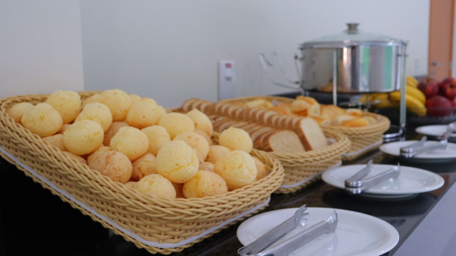 Een buffettafel met broodbaskets en een soepketel.
