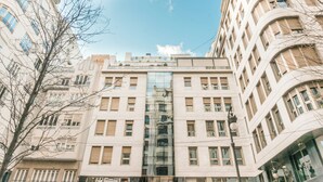 A multi-story building with a central glass facade, surrounded by other buildings. - Valencia Luxury - Boutique Center (Valencia)