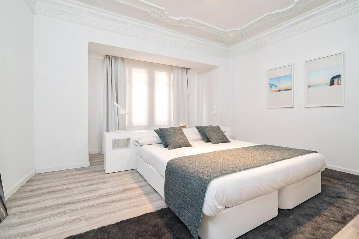 Een moderne hotelkamer met een groot bed, een zithoekje en uitzicht op zee.