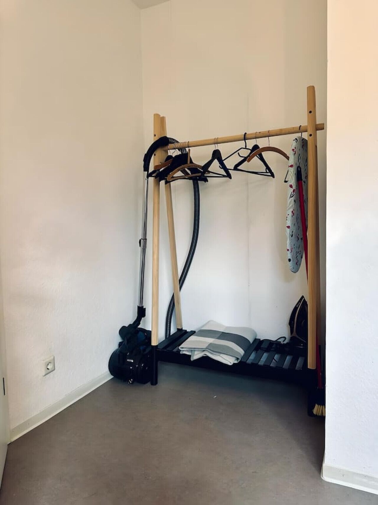 Pieni, kompakti huone, jossa on kerrossänky, imuri ja kenkäteline.