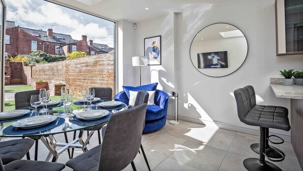 A modern kitchen with a dining area, large windows, and a view of the neighborhood. - Spacious, High Spec & Modern (Woodseats)