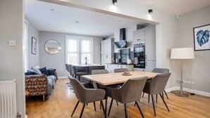 A modern apartment with a dining area, kitchen, and living space. - Stylish & Spacious 3 Bed Apartment with Parking (Sheffield)