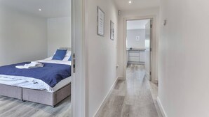 Una habitación de hotel moderna con cama, baño y zona de cocina.