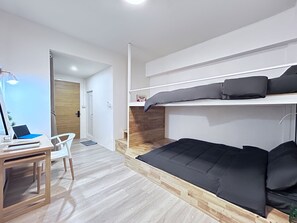 A modern bedroom with a bunk bed, a desk with a laptop, and a chair. - Letter Better Home (Bangkok)
