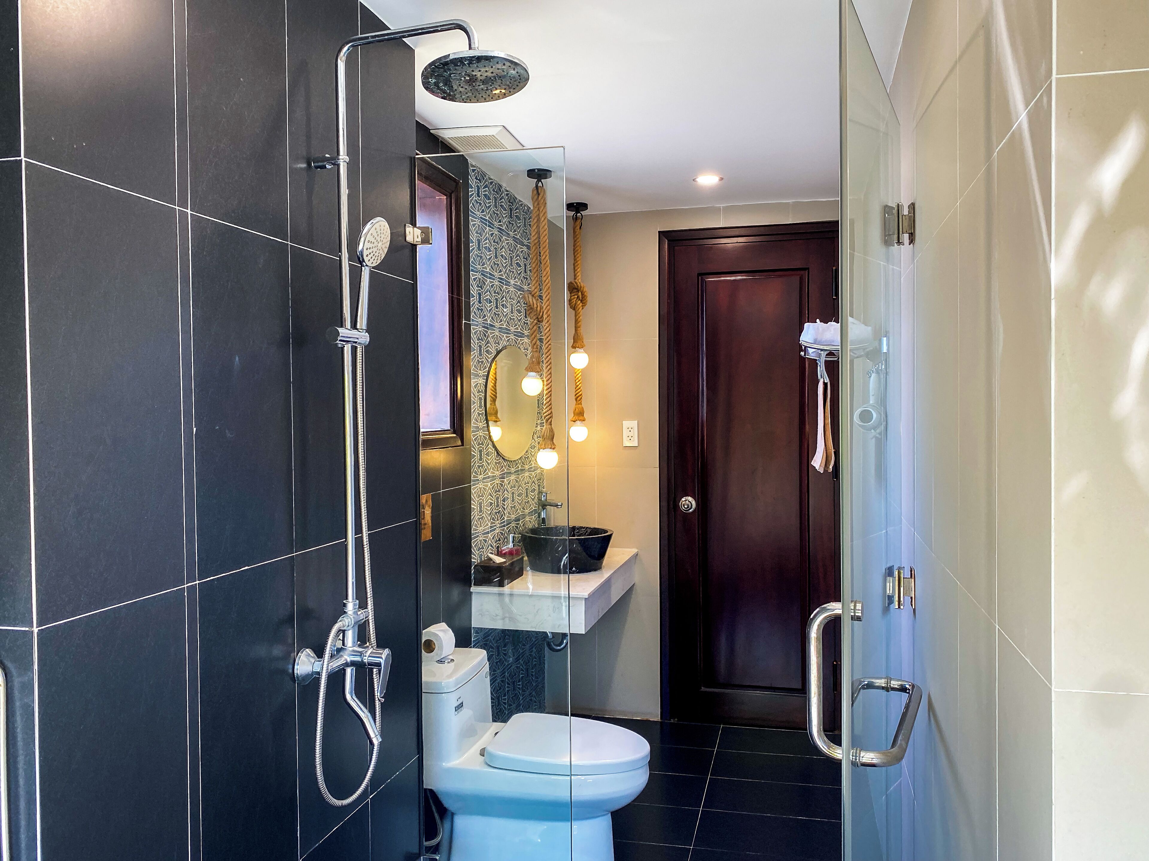 A modern bathroom with a shower, toilet, and sink.