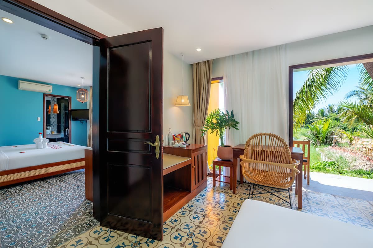A hotel room with a bed, a desk, a chair, and a view of the outdoors.