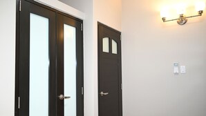 Two black doors with frosted glass panels, a wall-mounted light fixture, and a power outlet. - Jlo’s Place/Next to Airport/PrimeLocation/Fastnet (Carolina)