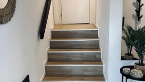 A staircase with wooden steps leading to a white door. - FeWo Burgblick - Sun terrace & castle view (Bad Bentheim)