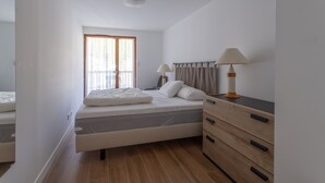 A bedroom with a bed, bedside lamps, a dresser, and a window with curtains. - Le Bierge - Station de ski accessible à pied (Vars)