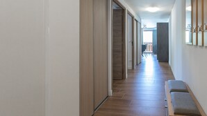 A hallway with wooden flooring, a bench, and a door leading to another room. - Le Bierge - Station de ski accessible à pied (Vars)