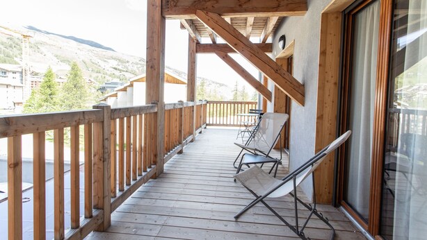 A wooden deck with a railing, a glass door, and a chair. - Le Bierge - Station de ski accessible à pied (Vars)