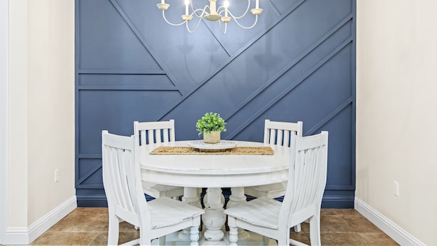 A dining area with a round table, white chairs, a chandelier, and a blue accent wall. - Welcome!  This apartment offers a spacious and comfortable place to stay.   (Hammond)