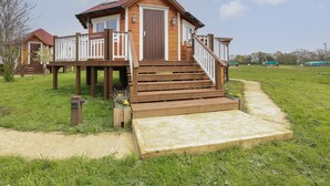 Een houten huis met een veranda en een trap naar de deur.