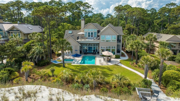 A large, two-story house with a swimming pool, surrounded by lush greenery and palm trees. - 34 Surf Scoter at The Sea Pines Resort (Hilton Head Island)