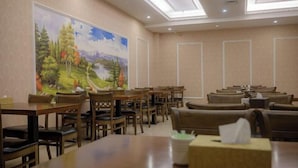 A conference room with multiple tables and chairs, a large painting on the wall, and a ceiling with skylights. - Victoria International Hotel (Kaiping Passenger Transport Terminal & Yihua Plaza Branch, Jiangmen) (Kaiping)