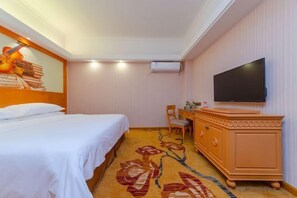 A hotel room with a bed, a TV, a dresser, and a carpet with a floral design. - Victoria International Hotel (Kaiping Passenger Transport Terminal & Yihua Plaza Branch, Jiangmen) (Kaiping)