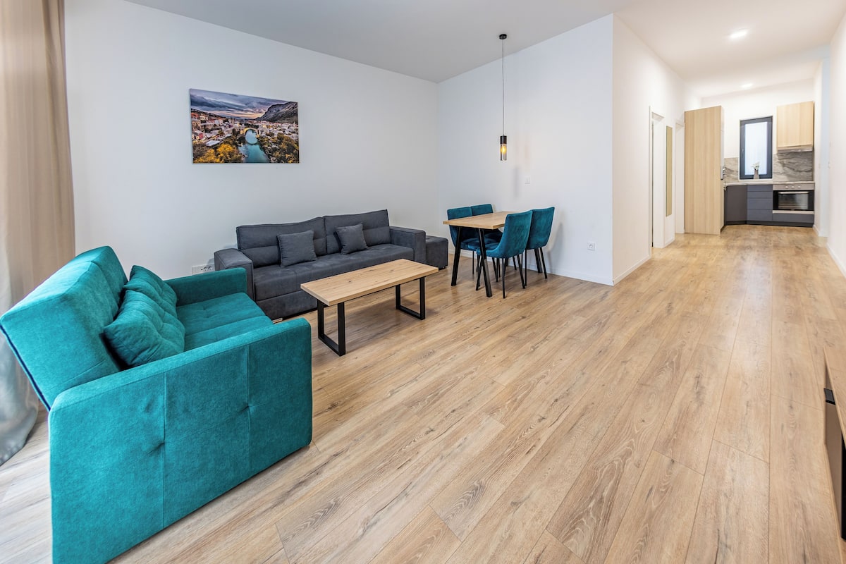 A modern living room with a sofa, a dining table, and chairs.
