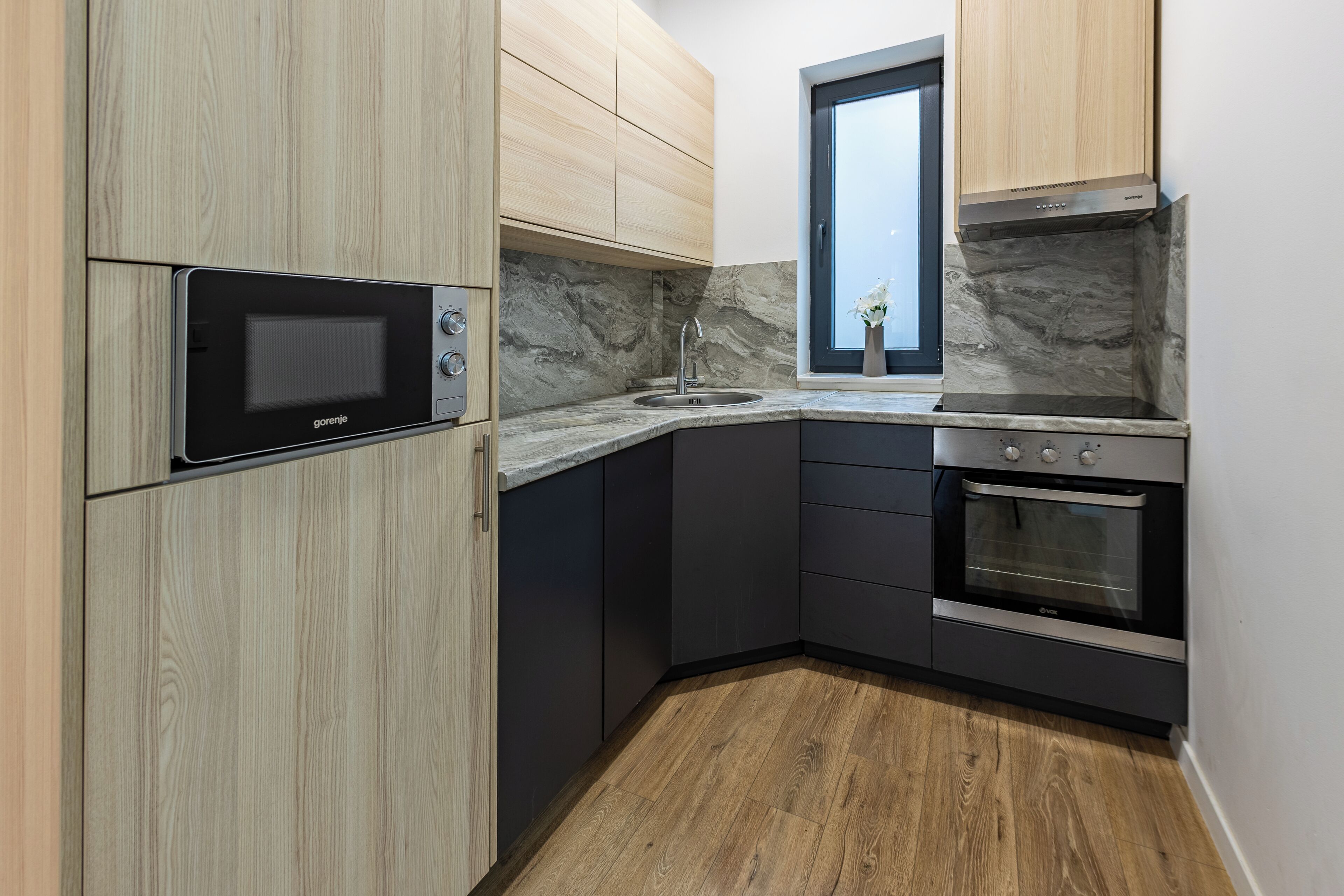 Una cocina moderna con microondas integrado, estufa y lavaplatos.