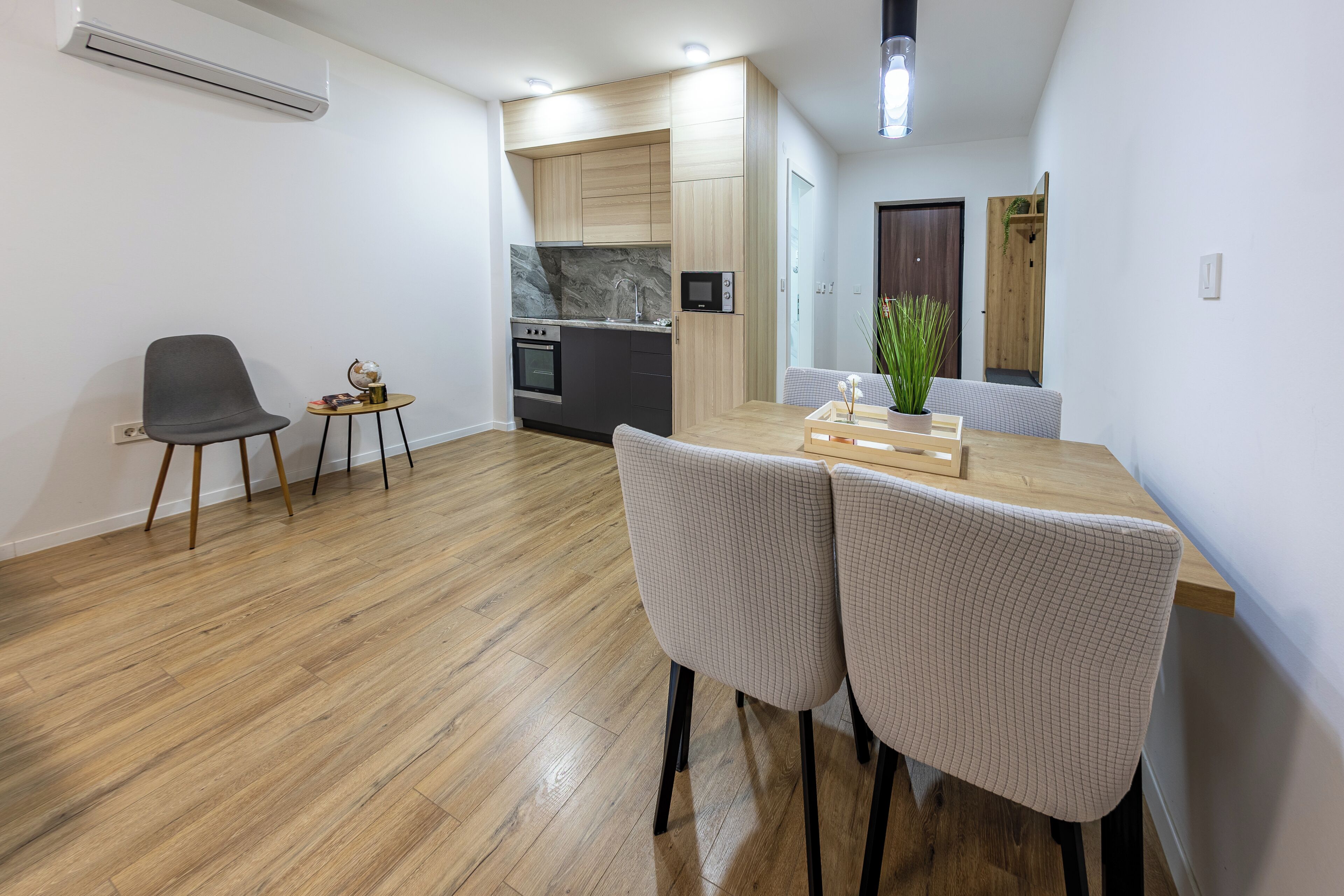 Een moderne keuken met houten kastjes, een inbouwoven en een magnetron.