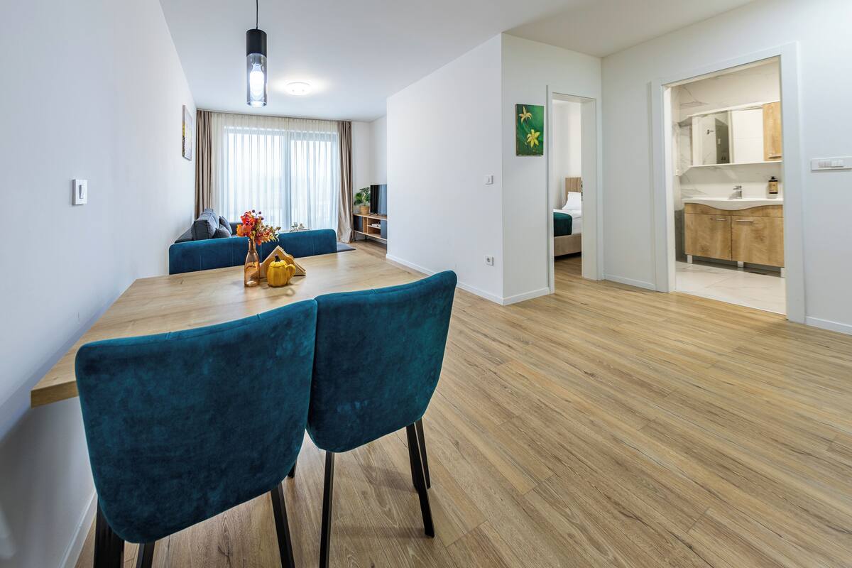 A modern living space with a dining area, a kitchen, and a bathroom.
