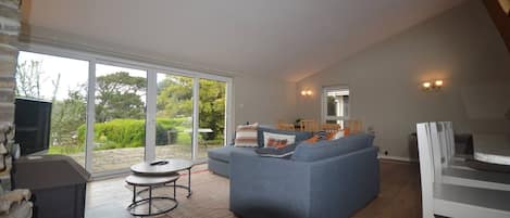 Een moderne woonkamer met een bank, een bijzettafeltje en een televisie.