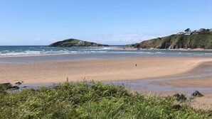 A beach with a clear view of the sea, a sandy shore, and grassy hills in the background. - Carew, Bantham Beach in S. Devon (Bantham)