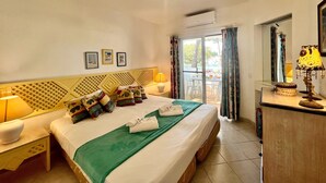 A hotel room with a bed, a desk, a chair, a lamp, and a window with curtains. - ALBUFEIRA BALAIA GOLF VILAGE 2 WITH POOL by HOMING (Albufeira)