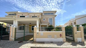 A two-story house with a gated entrance, a covered porch, and a tiled driveway. - PÊRA AMAZING VILLA WITH POOL by HOMING (Pêra)