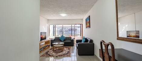 A living room with a sofa, coffee table, and TV.