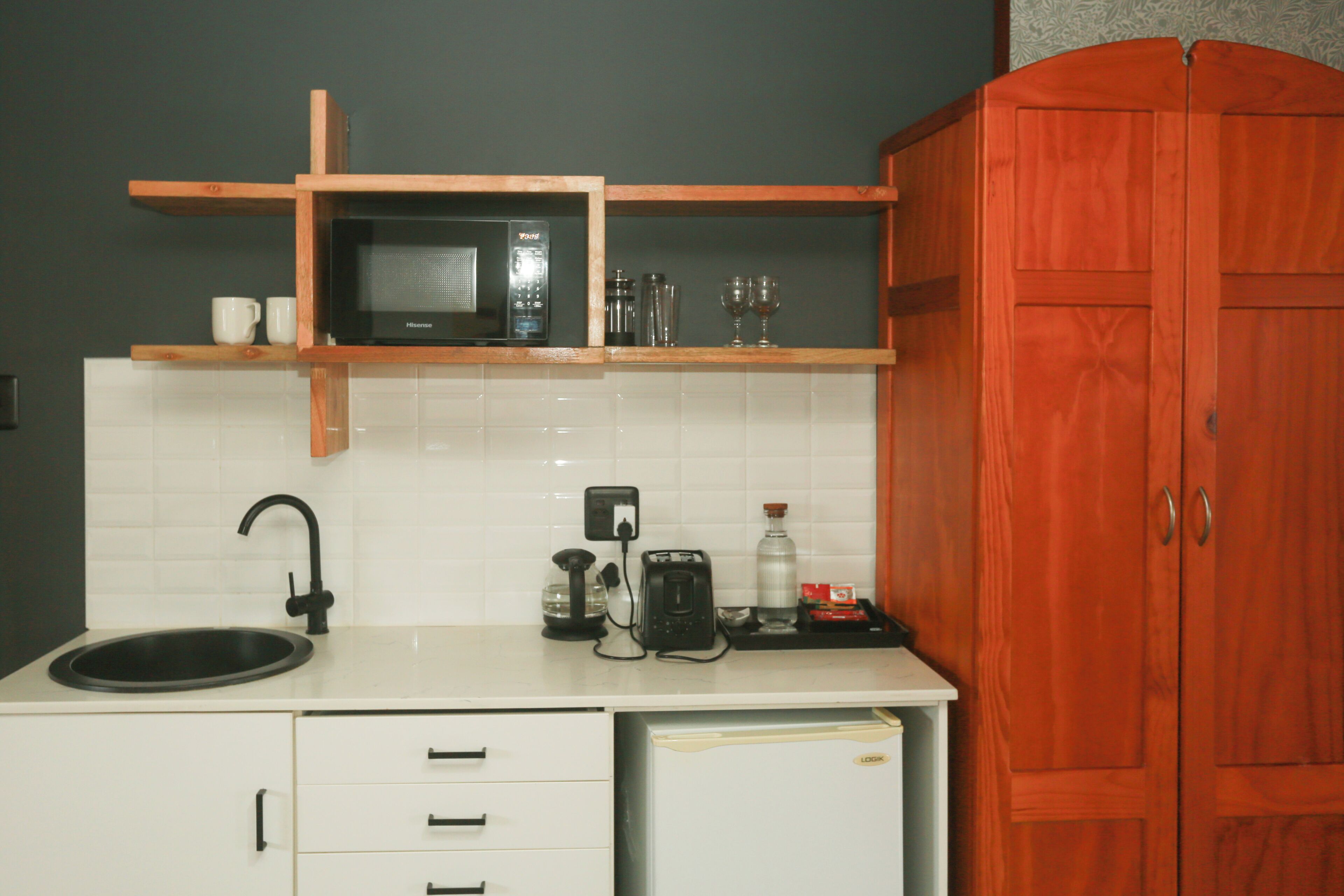 A kitchen with a microwave, coffee maker, and cabinets.
