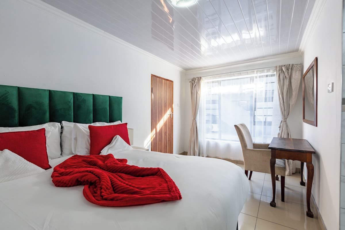 Una habitación de hotel con una cama grande, un escritorio y una silla.