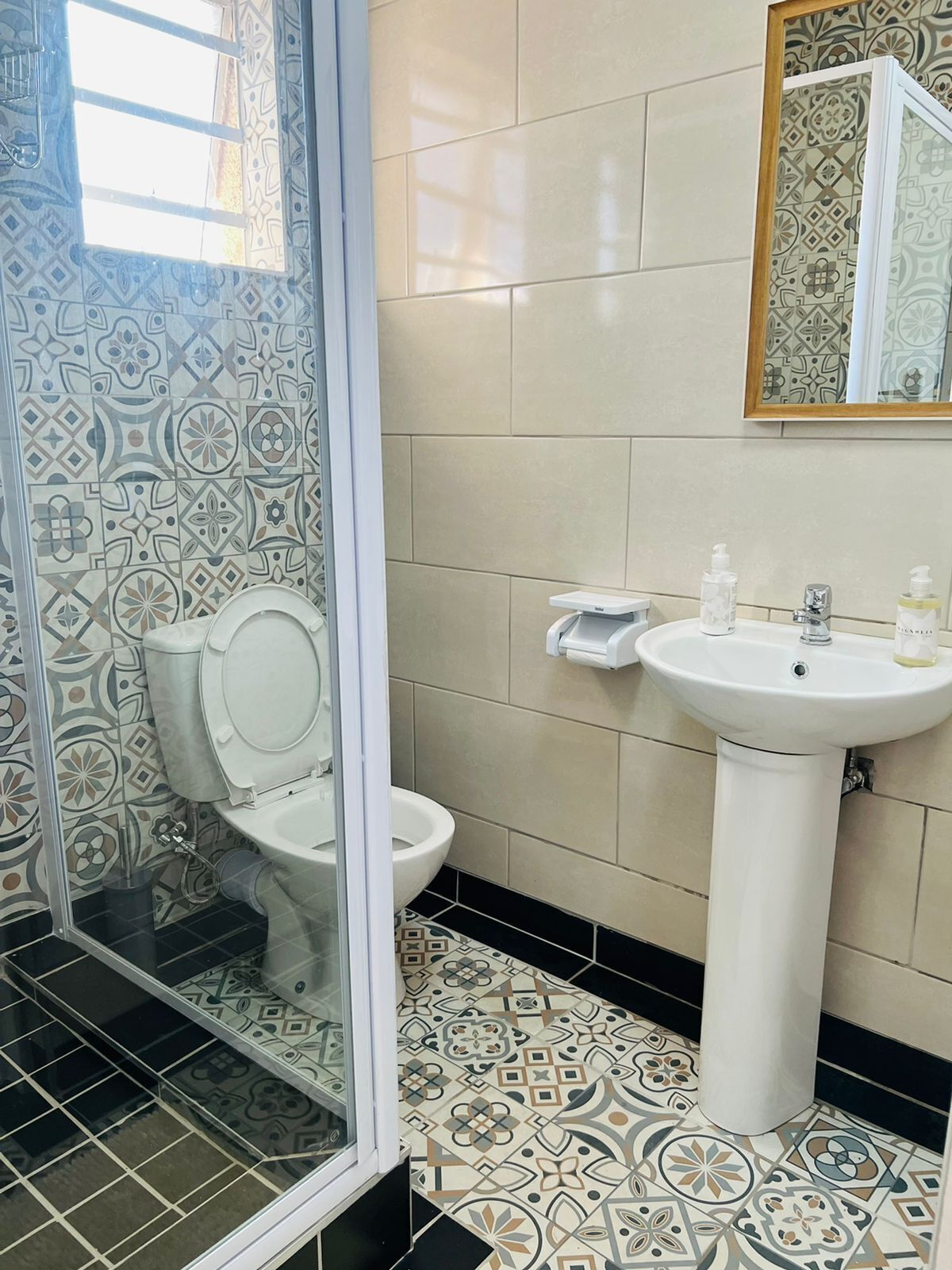 A bathroom with a toilet, a sink, and a shower area.