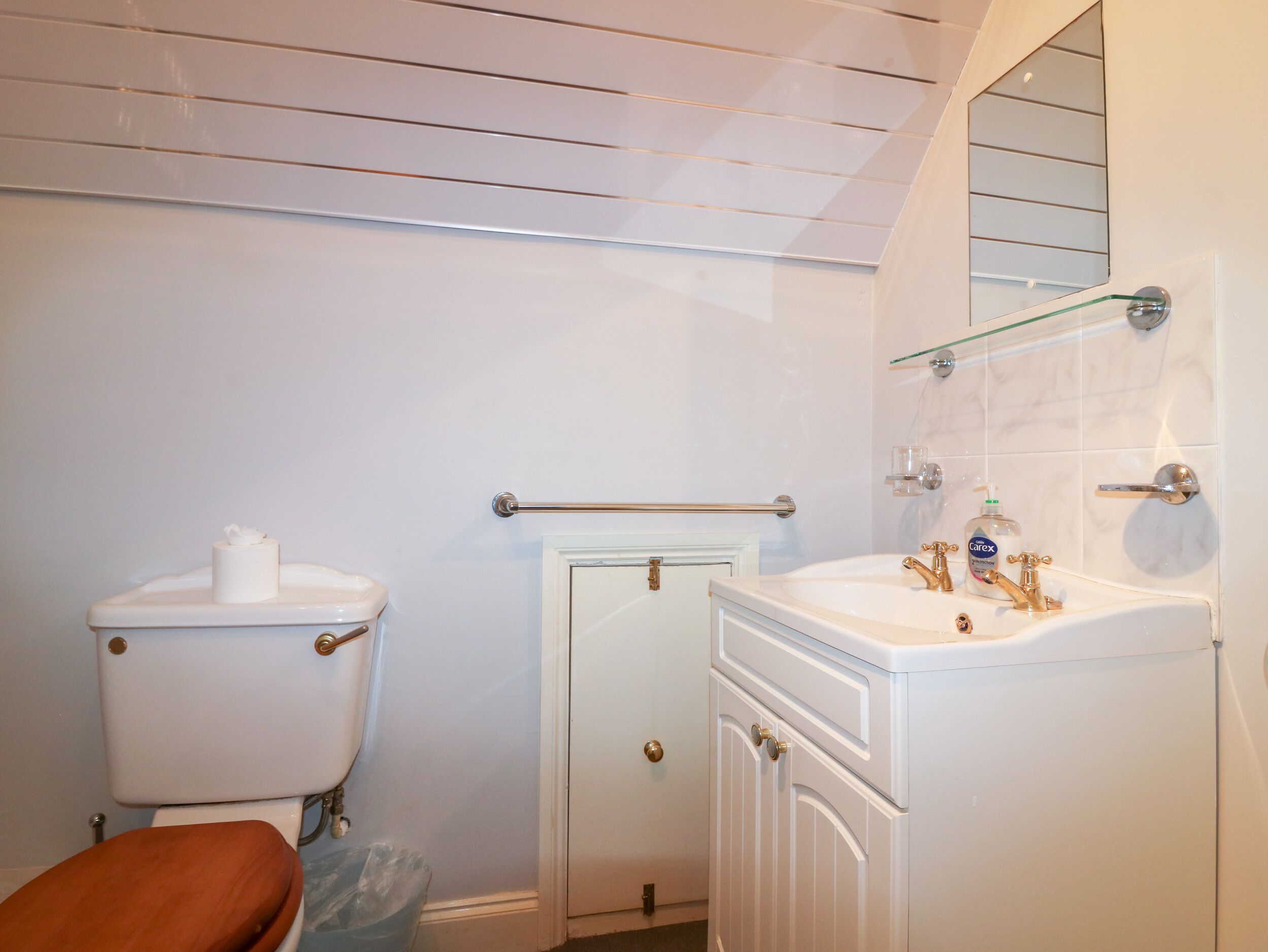 Een badkamer met toilet, wastafel en douche.