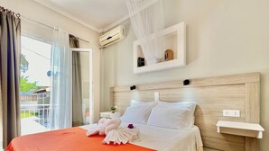 A hotel room with a large bed, a bedside table, a nightstand, a wall-mounted shelf, and a balcony with a view. - Sidari Beach Villa with private pool (Sidari)