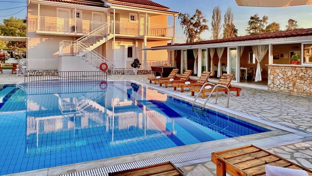 A two-story hotel with a swimming pool, outdoor seating, and a covered area. - Sidari Beach Villa with private pool (Sidari)