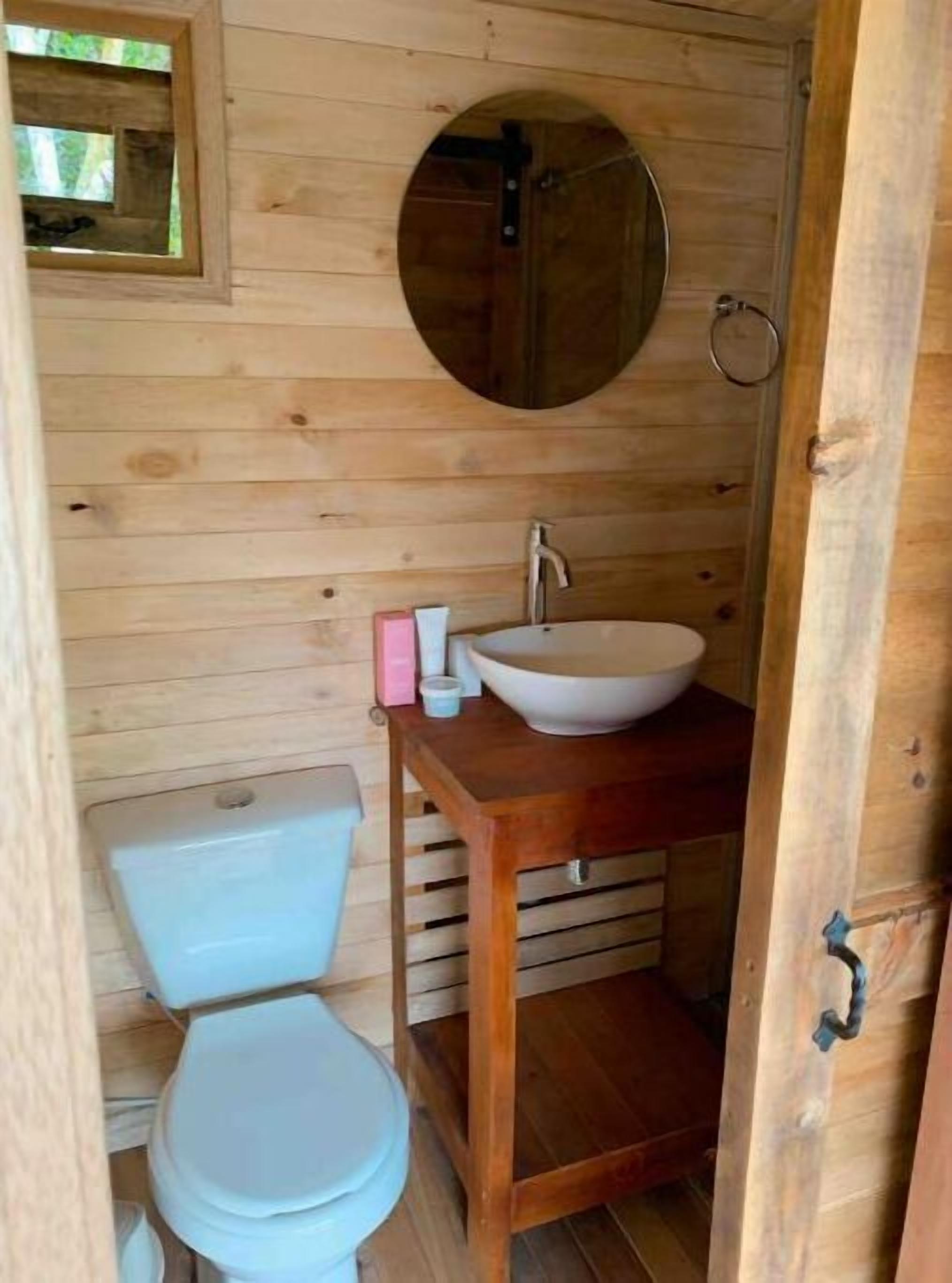 Un baño rústico con tocador, lavabo y espejo.