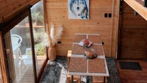 A cozy wooden room with a round mirror, a wolf painting, and a table with a woven placemat.