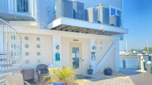 A hotel with a modern design, featuring a prominent staircase, a potted plant, and a view of the marina.