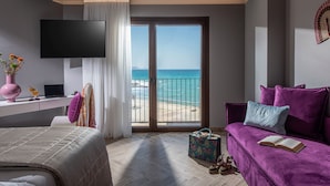 Une chambre moderne avec une grande fenêtre, un lit, un canapé, un bureau avec un ordinateur portable et une télévision.